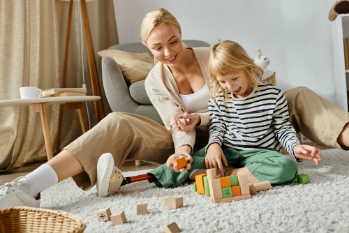 Child playing with blocks alongside guardian.