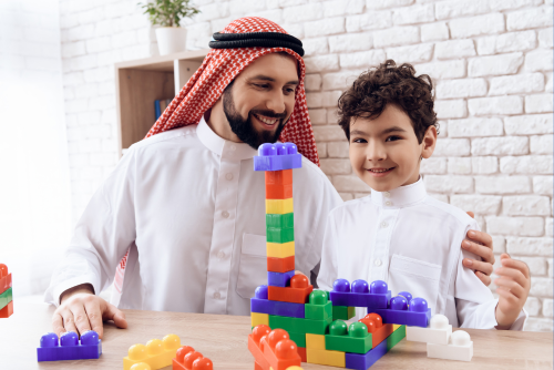 Adult and child playing with building blocks.